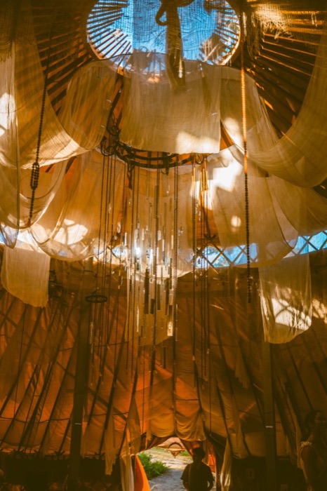 Chandelier and mirror-shard installation hanging beneath the yurt's oculus