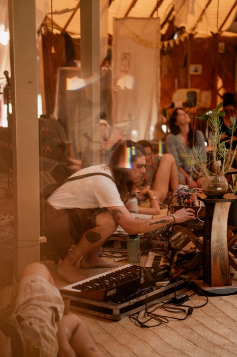 DJ set at the synth corner, Korg Prologue lit beneath the canopy