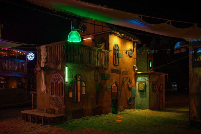 Lantern-lit facade of the Sandlantis village at night