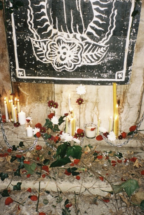 Full altar piece lit by candles and surrounded by flowers